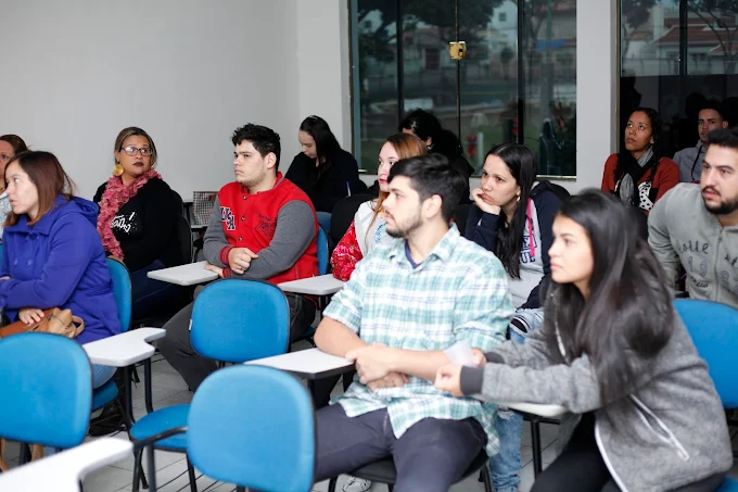 Sala de aula interativa com cadeiras organizadas, TV de projeção e esqueleto anatômico